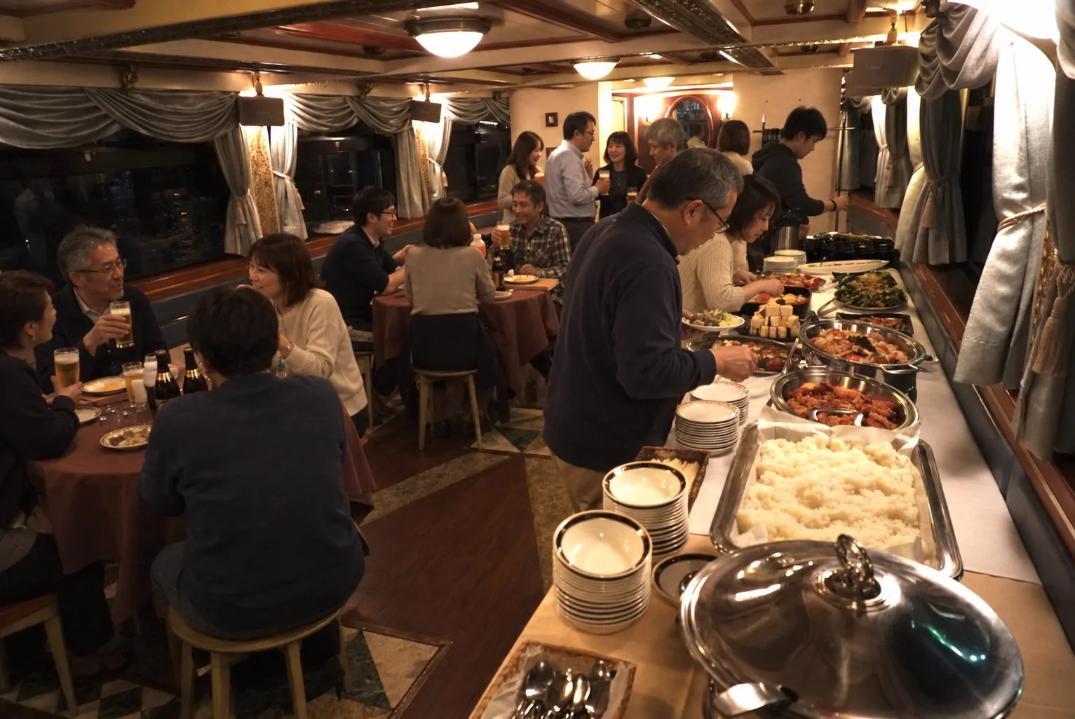 船内で料理とビールを囲んで歓談する様子