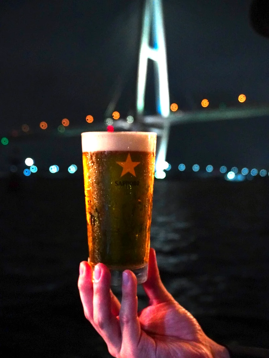 名港トリトンの夜景を背に掲げた生ビール