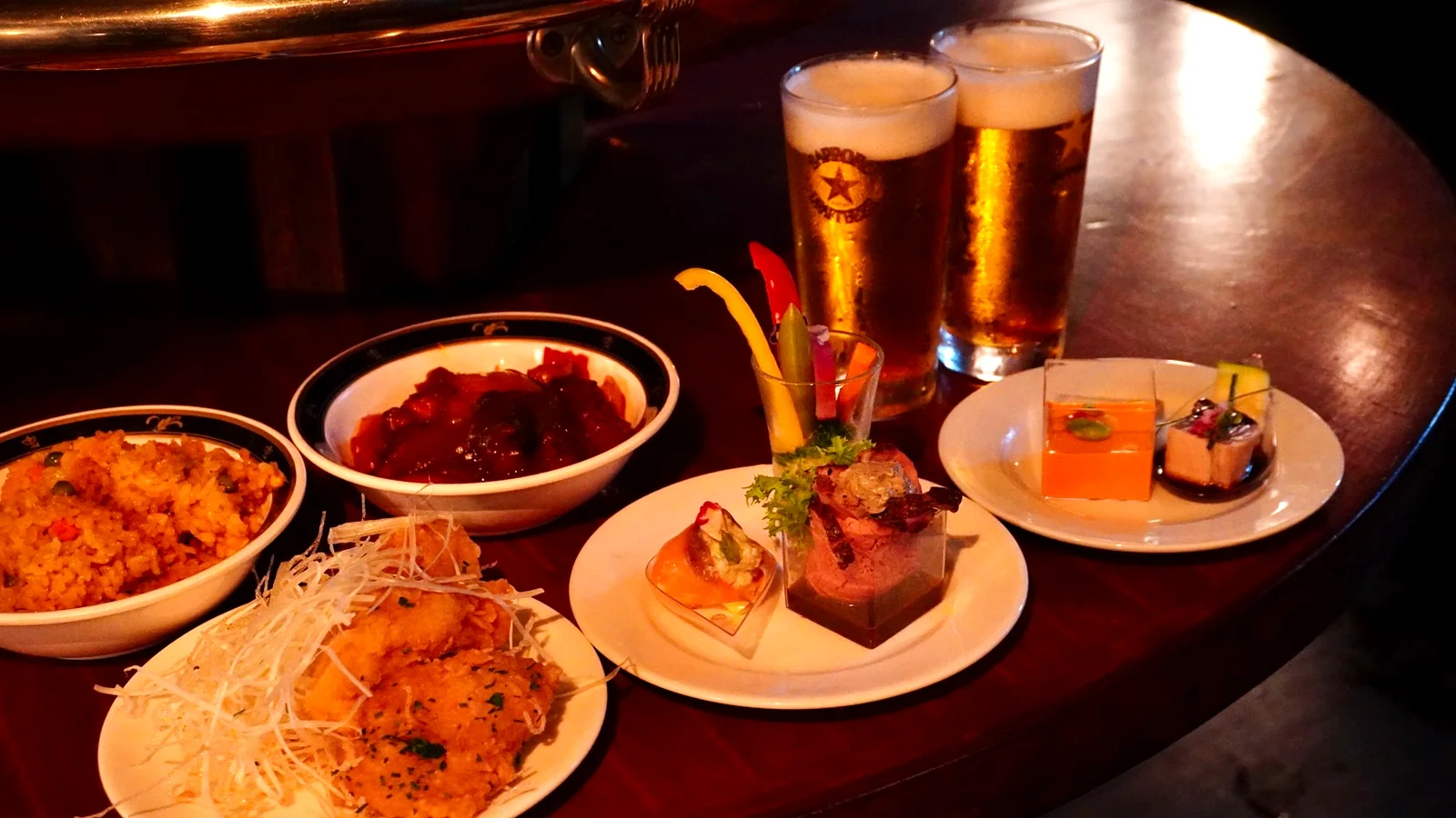 船上のテーブルに並ぶ生ビールと洋風コース料理